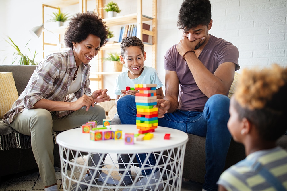portrait-of-black-family-playing-a-game-at-home-to-N9KCQZB