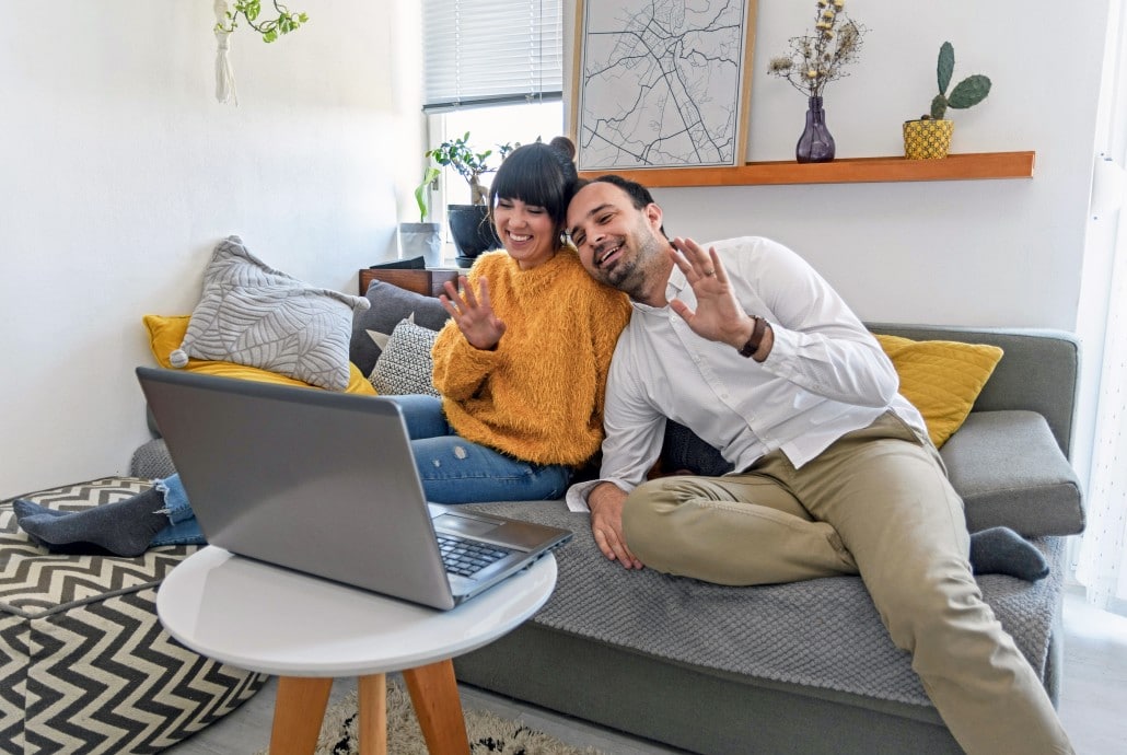 young-couple-sitting-on-sofa-smiling